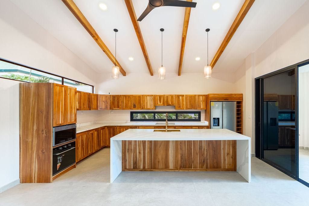 Casa Soma modern kitchen with wood cabinets and quartz countertops – 1 Casa Soma Playa Avellanas | Modern Home for Sale